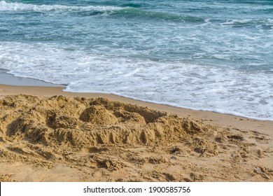 a sand castle built by children on the beach on a sunny day. sand castle on the background of the blue sea - Powered by Shutterstock