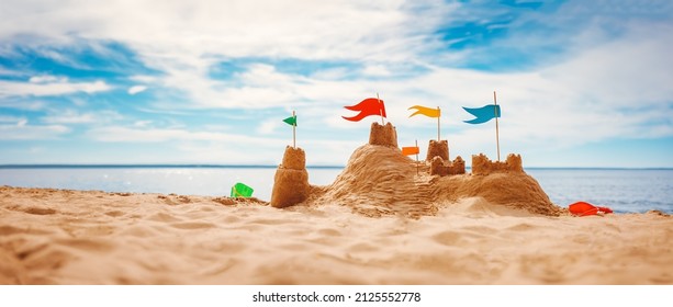 Sand castle with colourful flags on the beach of the sea. Panoramic view. Concept of the vacation and tourism. - Powered by Shutterstock