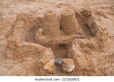 Sand Castle With A Water Moat Made On A Beach. 