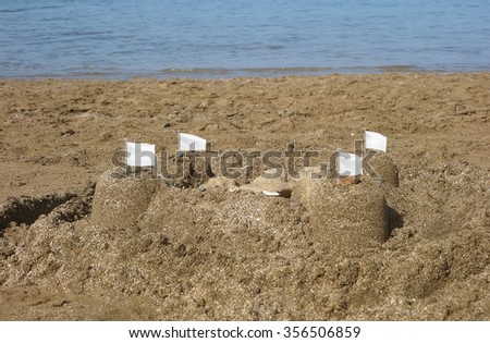 Sand castle with white flags , capitulation concept