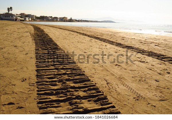Sand\
cleaning machine tracks, world beach cleaning\
day.