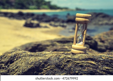Sand Clock on rock with sea view and sun light. give time relaxing Concept