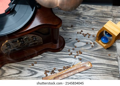 Sand Clock And Scattered Grains Of Roasted Coffee On A Vintage Rough Wooden Background. Sandglass, Hourglass Or Egg Timer On Wooden. Antique Style Wooden Background.