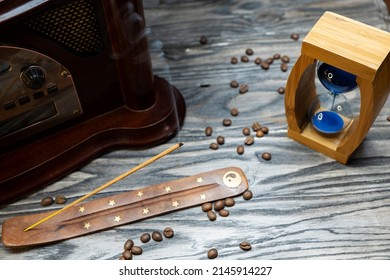 Sand Clock And Scattered Grains Of Roasted Coffee On A Vintage Rough Wooden Background. Sandglass, Hourglass Or Egg Timer On Wooden. Antique Style Wooden Background.