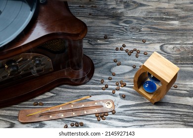 Sand Clock And Scattered Grains Of Roasted Coffee On A Vintage Rough Wooden Background. Sandglass, Hourglass Or Egg Timer On Wooden. Antique Style Wooden Background.