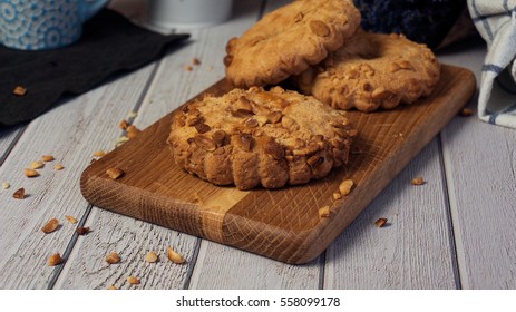 Sand cookies with almonds on wooden board.