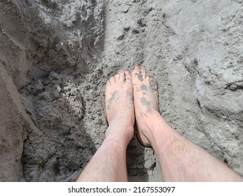 Sand Covered Toes And Feet In The Sand At A Beach. The Man's Feet Are Sitting At The Bottom Of A Whole In The Sand.