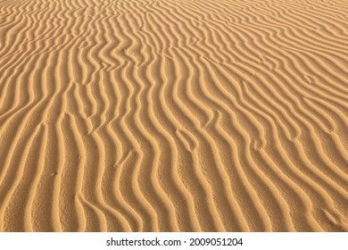 Sand Desert Ripples Background. Wind Ripples On Yellow Sand.