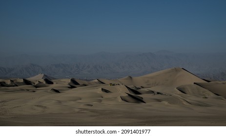 Sand Dunes At The Desert Oasis Of Huacachina Tourists Take Pictures And Ride Drive Dune Buggy Sand Board With Guides Before Staying The Night.