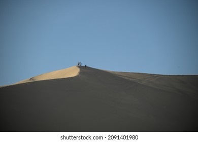 Sand Dunes At The Desert Oasis Of Huacachina Tourists Take Pictures And Ride Drive Dune Buggy Sand Board With Guides Before Staying The Night.