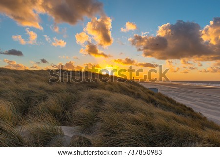 The sand dunes of Oostende (Ostend in English) and Bredene at sunset with the skyline and pier of Ostend in the background, West Flanders, Belgium.