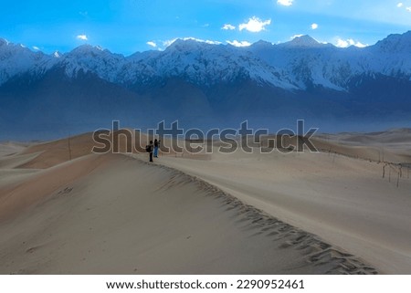 sand dunes with snow mountains, desert in the snow mountains
wonderful desert in snowy peaks, landscape with mountains and sand dunes 