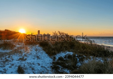 Sand dunes at sunset in the snow, Oostende, Belgium.