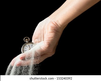 Sand flowing between fingers of a hand holding an antique pocket watch - Powered by Shutterstock