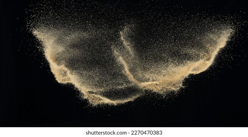 Sand flying explosion, Golden sand wave explode. Abstract sands cloud fly. Yellow colored sand splash throwing in Air. black background Isolated high speed shutter, throwing freeze stop motion