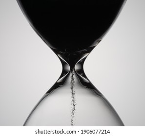Sand moves through hourglass. Close up of hour glass clock. Old time classic sandglass timer. Hourglass as time passing concept for business deadline, urgency and running out of time.