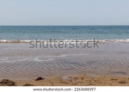 Sand on the sea coast in Turkey. Texture of beige sand on a sunny day can be used for background