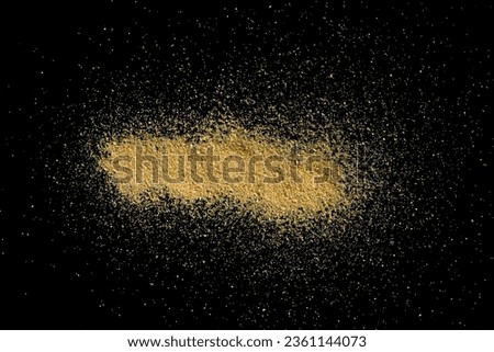 Sand scattered on a black surface.