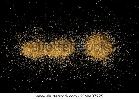Sand scattered on a black surface.