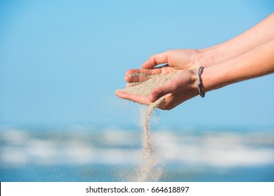 Sand Slipping Through Young Girl's Fingers