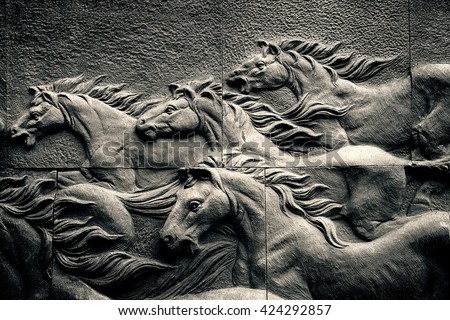Sand stone sculpture brick wall of herd horse run background, low key black and white, high contrast and hard lighting tone