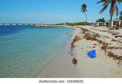 Sand, Surf, Palm Trees And Child's Toys Washed By Emerald Waters Along Bahia Honda State Park Beach In The Lower Keys Of Florida.