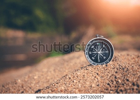 Sand surrounds the compass, capturing the essence of exploration and adventure.