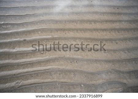Sand texture with abstract forms of water at low tide

