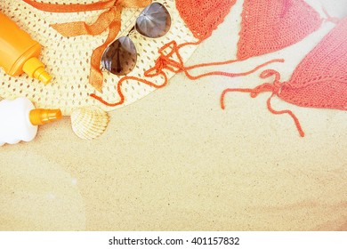 Sand Texture (background) With Hat, Swimsuit, Sunscreen (suncream), Sunglasses On The Beach. The Sun Drawing In The Sand. The Empty Pattern For Message. Summer Vacations Concept. Copy Space.