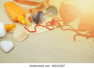 Sand Texture (background) With Hat, Swimsuit, Sunscreen (suncream), Sunglasses On The Beach. The Sun Drawing In The Sand. The Empty Pattern For Message. Summer Vacations Concept. Copy Space.