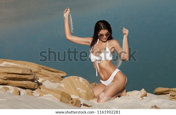 Sand as the time slips through your fingers. Girl\
holding a sand sea background. concept of vacation in warmer\
climes, the trip to the\
sea