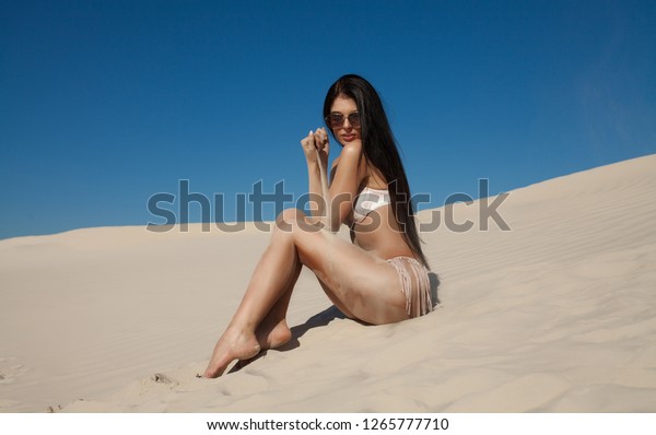 Sand as the time slips through your fingers. Girl\
holding a sand sea background. concept of vacation in warmer\
climes, the trip to the\
sea