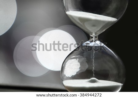 Sand Timer with white sand. With beautiful bokeh background. 
