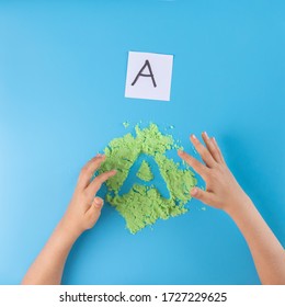 sand tray writing, letter practice for kids, preschool writing activity, kids hands, top view - Powered by Shutterstock