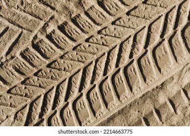 Sand Tyre Mark Background. Tire Track Shape. Trail Lines On Dry Brown Sand Pattern. Road Construction Site Backdrop. Heavy Machinery Imprint. Dried Mud Vehicle Wheel Shape.