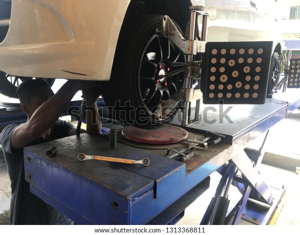 Sandakan, Sabah. Malaysia - Feb 07, 2019 : Car\
automobile wheel alignment maintenance works repair at automotive\
service center workshop. Technical maintenance wheel alignment\
correction fixation\
MOT.