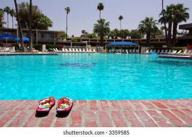 Sandals Next To Large Empty Swimming Pool In Palm Springs, California