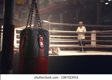 A Sandbag Hanging In Front Of A Boxing Ring Have A Janitor Was Cleaning 