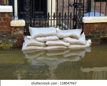 Sandbags stacked in front of house in York flooded street.