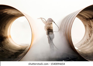 Sandblasting or abresive blasting for steel pipes before painting and coating. - Shutterstock ID 1540094654