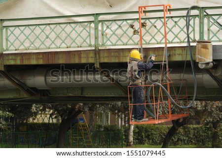 The sandblasting process. Worker performs blasting of the iron bridge. Hard worker. 