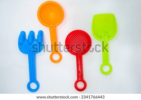 Sandbox toys such as colorful rakes on a white background