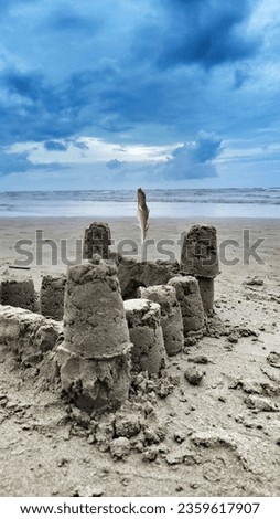 Sandcastle with feather at the beach