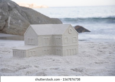 Sandcastle In The Shape Of House On Beach