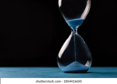 Sandglass, Egg Timer With Blue Sand On Black Background, Time Passing Concept For Business Deadline