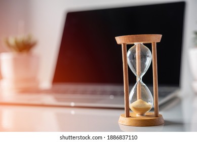 Sandglass on laptop computer , time countdown to deadline