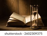 Sandglass with open ancient book. Study of literature, history, culture.