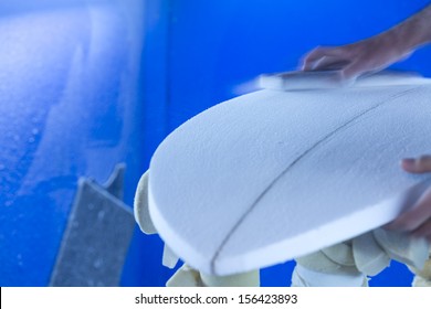 Sanding/ A surfboard maker sands a foam core into shape - Powered by Shutterstock