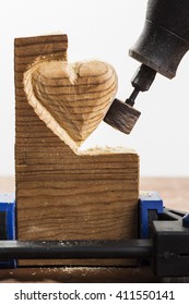 Sanding Wood In Heart Shape With A Rotary Tool, On White