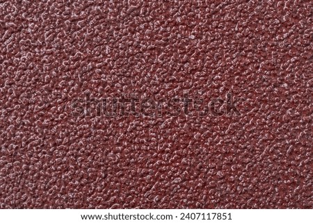 sandpaper surface texture, close-up macro view of P40 coarse-grit abrasive commonly used for heavy sanding tasks, abstract background in full frame